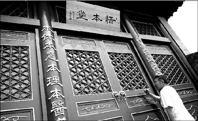 一名顾客在“悟本堂”已关闭的大门旁敲门,想一探究竟。本报记者 王苡萱 摄 一名顾客在“悟本堂”已关闭的大门旁敲门,想一探究竟。本报记者 王苡萱 摄