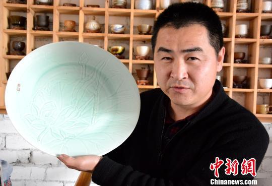 黄涛展示他自己工厂加工的克拉克瓷。 张金川 摄