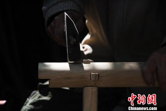 据了解,徐光祥已掌握30余种榫卯结构制作技艺。图为徐光祥组合榫卯结构桌腿。 郝学娟 摄