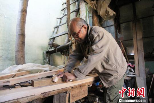 自18岁开始学习明式家具制作工艺,徐光祥与木头结伴近50年。徐光祥介绍说,该技艺由明初山西工匠带入济南市董家镇,在当地传承发展了几百年,保留了中国古代家具制作技艺中大量优秀木工工艺。图为徐光祥在刨木块。 郝学娟 摄