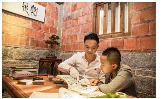 〈图一〉林志坚先生在给下一代讲解古钱知识,这就是一种传承