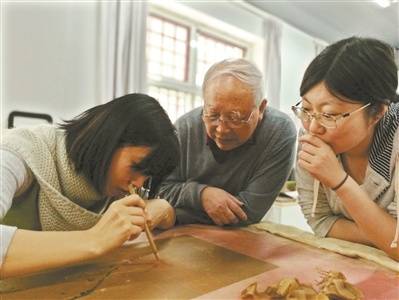 徐建华老师指导张笑艳展开修复工作。