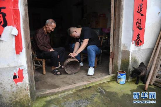 6月12日,罗小龙在一位老乡家收集文物。新华社记者 周密 摄
