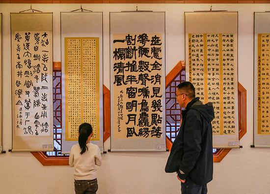 观众在某书画展现场参观书法作品。图片来源:半月谈多方利益促成“官位崇拜”